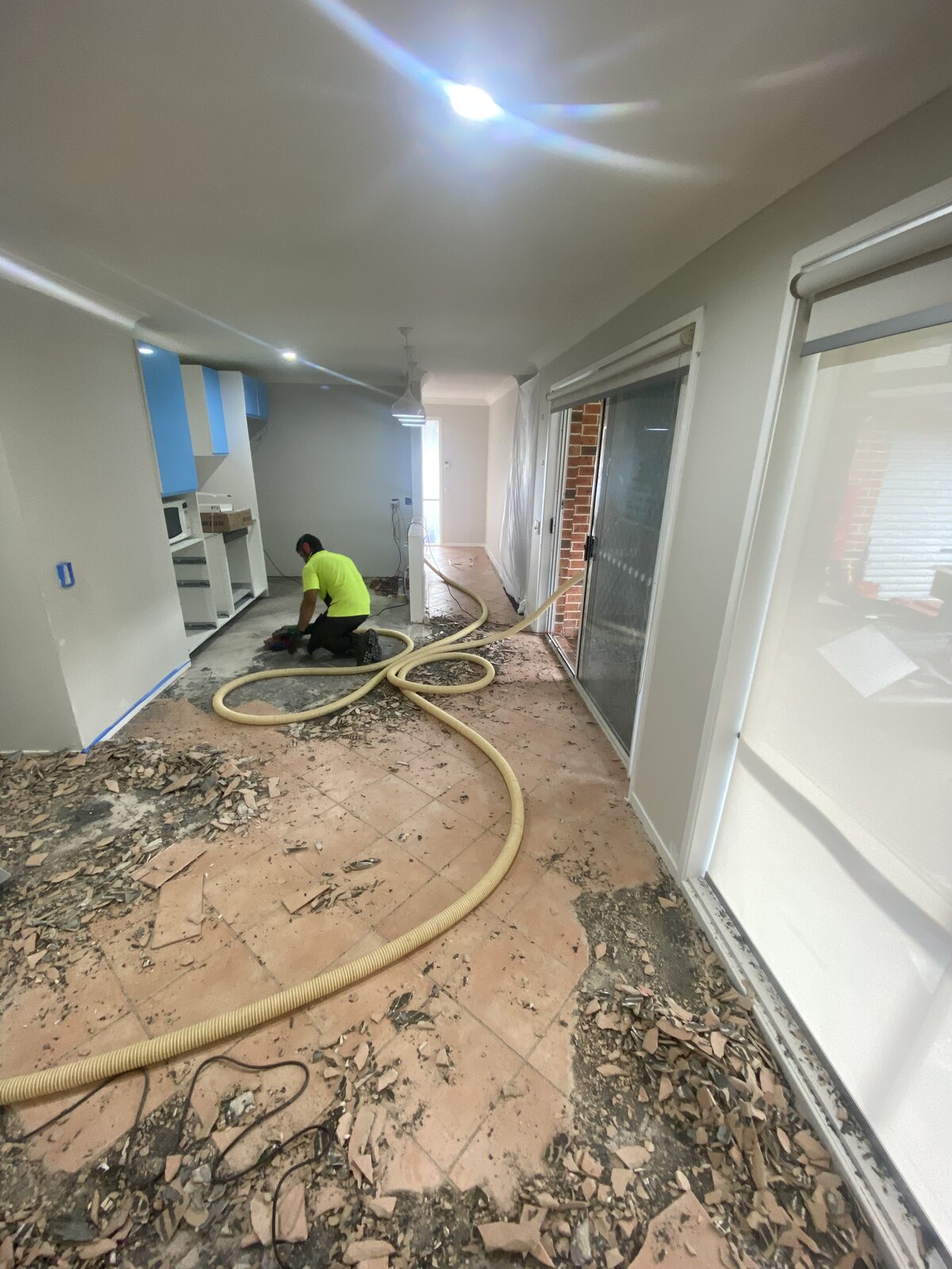 Prestige Demo worker removing flooring with dust extraction equipment